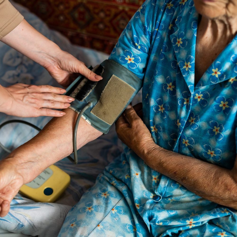 Female doctor measuring blood pressure of senior woman