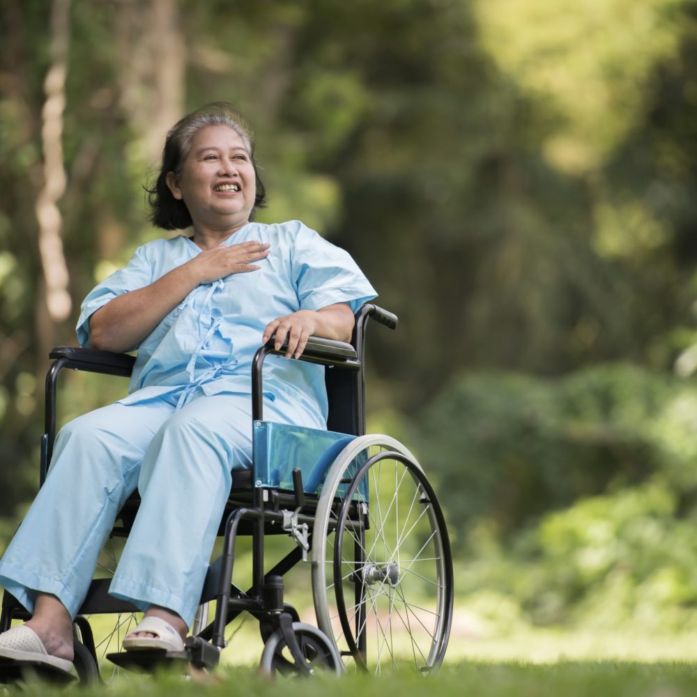 Lonely elderly woman sitting sad feeling on wheelchair at garden in hospital